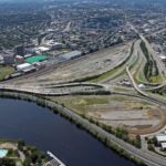 An aerial view of the Allston trainyards and the Charles River on a sunny day.