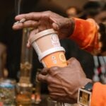 A person hold cups of Cloud Creamery ice cream and a hand-rolled joint