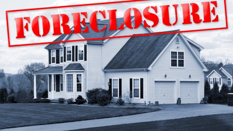A foreclosed house with a red foreclosure stamp running along the top of the picture.