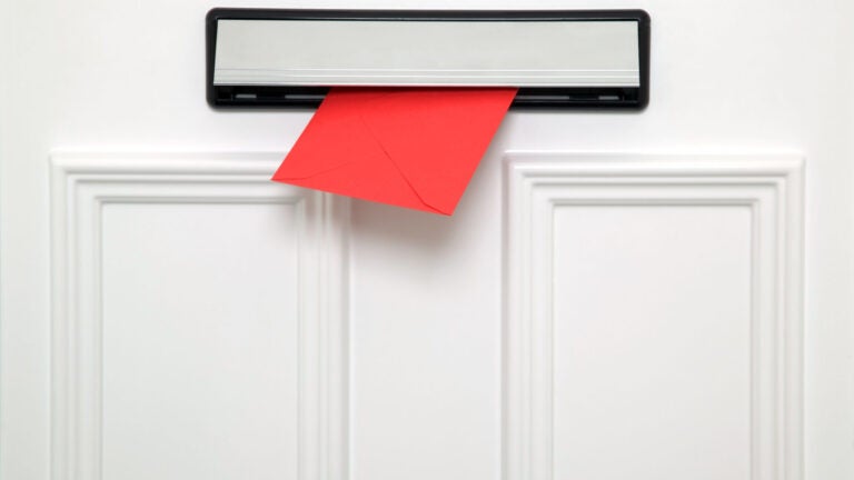 Red letter coming through a chrome letterbox on a white door. Could be a Valentines,Christmas,Birthday or other greetings card.