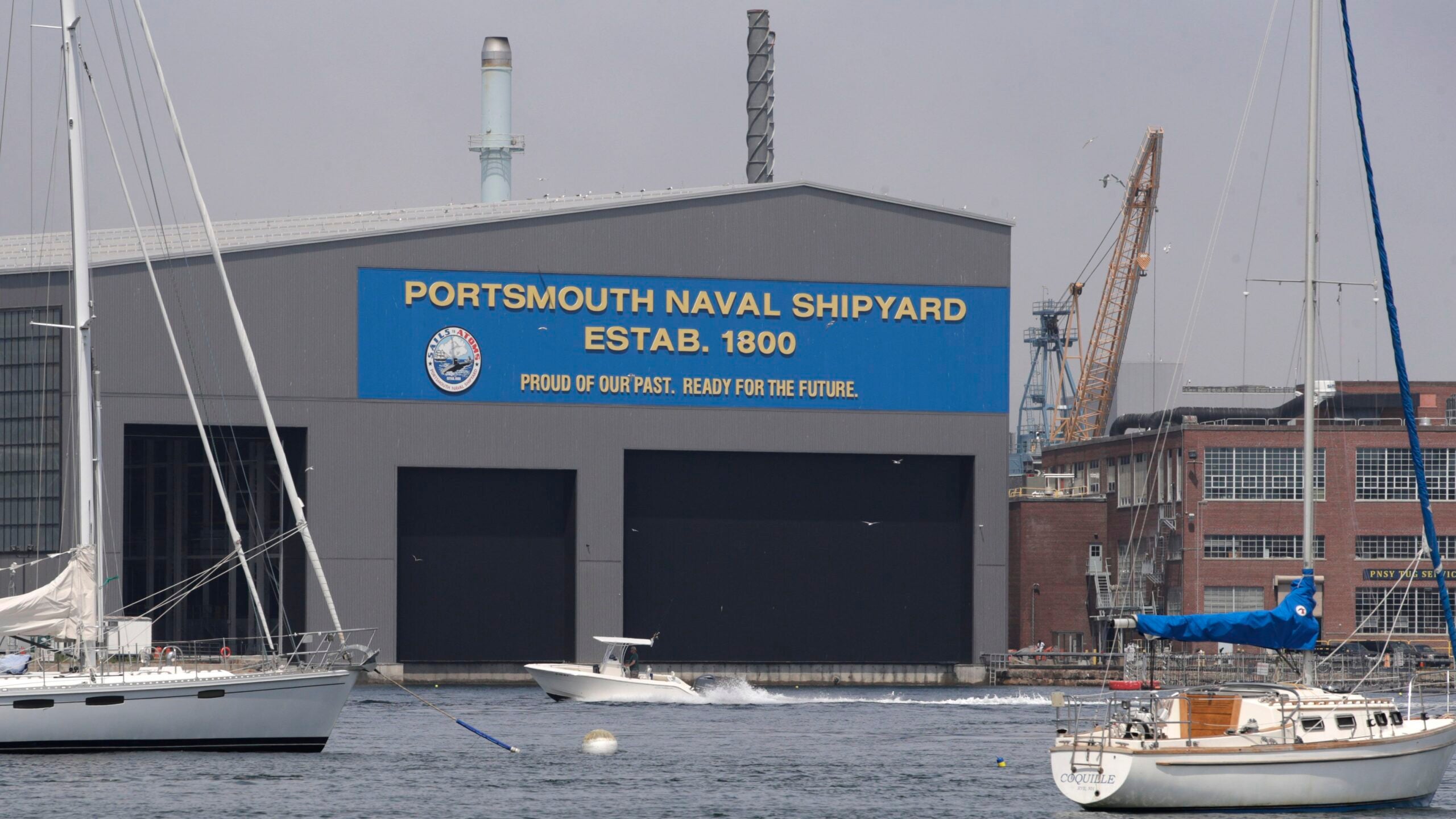 A small pleasure craft passes through the Portsmouth Naval Shipyard in 2020.