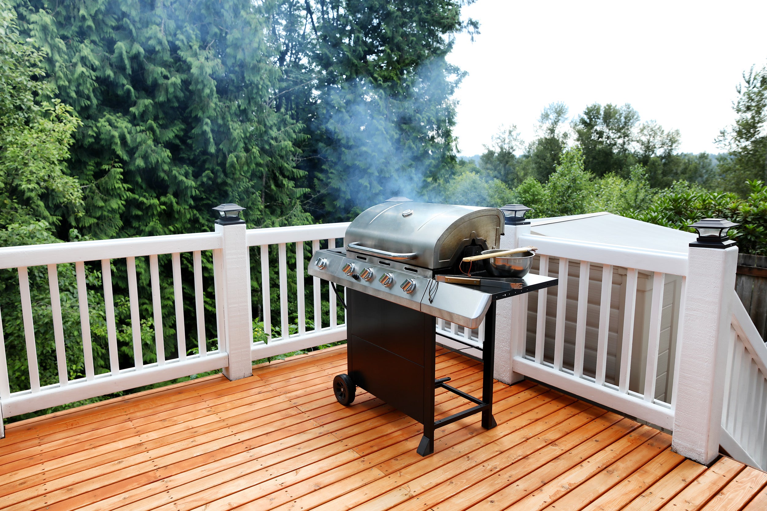 Barbecue grill cooking with visual smoke in open outdoor deck du