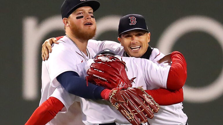 Kiké Hernández walks through the Red Sox dugout as an opponent