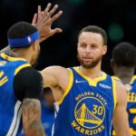 Golden State Warriors guard Stephen Curry (30) high fives Golden State Warriors guard Gary Payton II (0) during the second quarter of Game 6 of basketball's NBA Finals against the Boston Celtics, Thursday, June 16, 2022, in Boston.