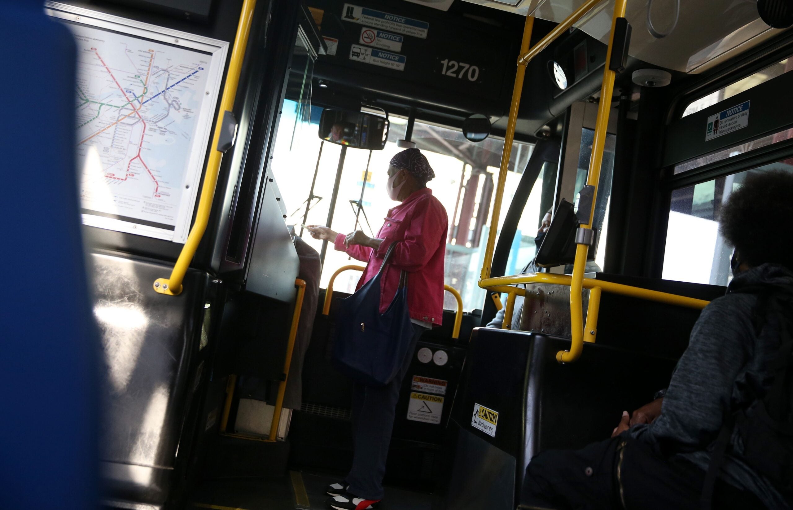 A passenger boards an MBTA bus in 2021.