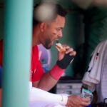 Xander Bogaerts eats a peanut butter and jelly sandwich in the Red Sox dugout.