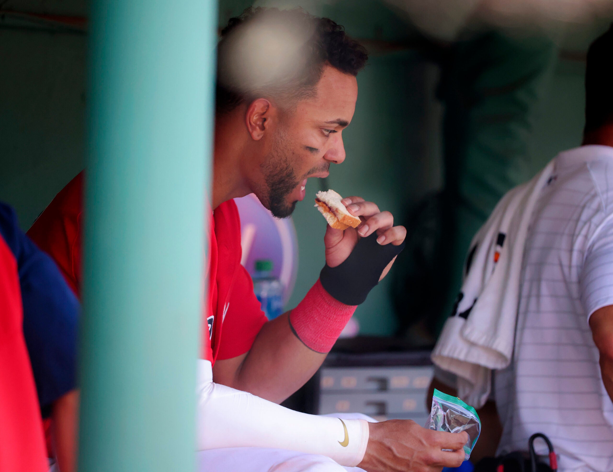 Xander Bogaerts eats a peanut butter and jelly sandwich in the Red Sox dugout.