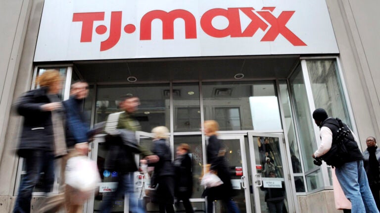 Several people walk past a T.J.Maxx store in Boston.