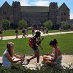 Boston College students sit on a wall at the BC campus.
