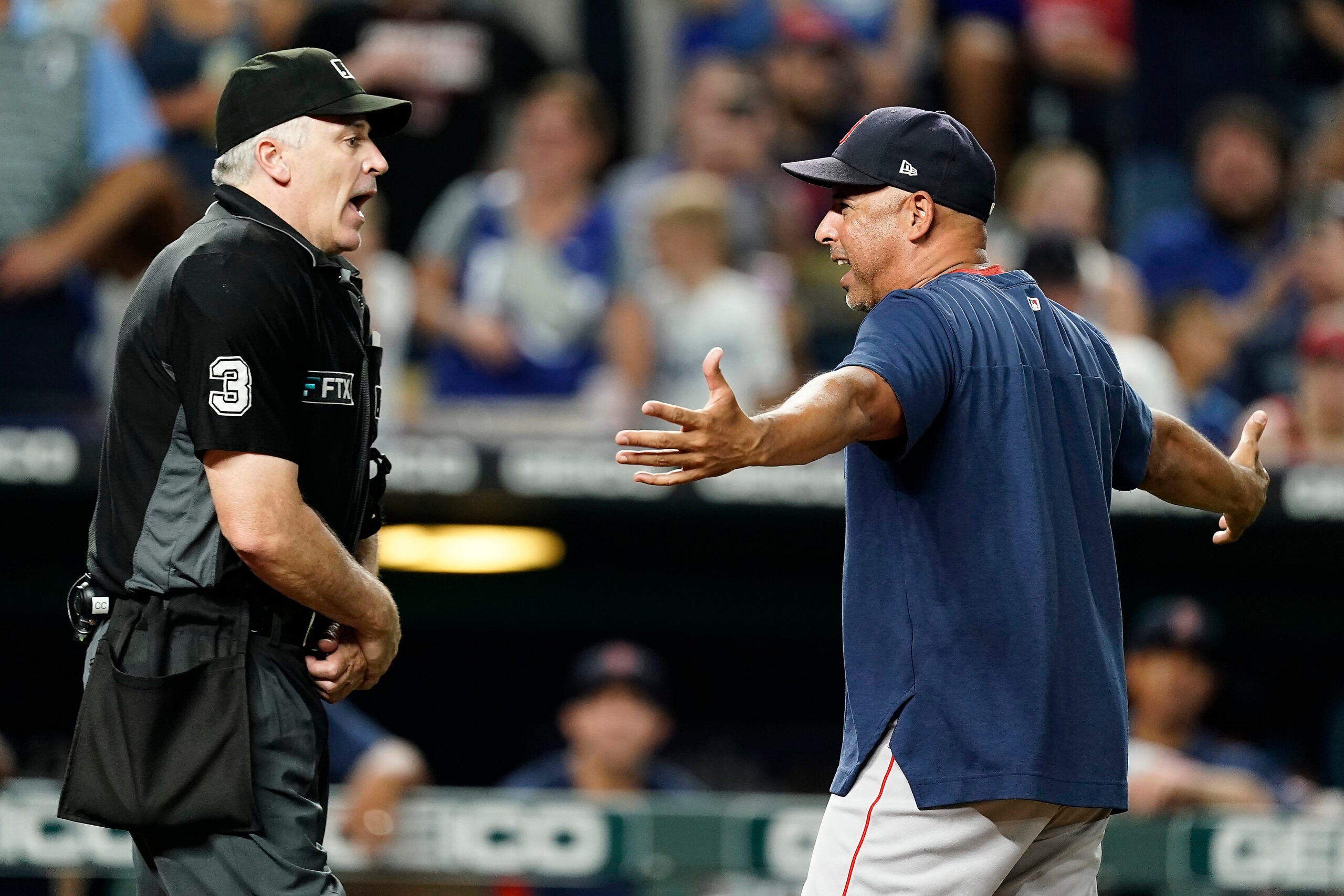 Alex Cora and umpire Bill Welke argue, with Cora's arms out, exasperated.