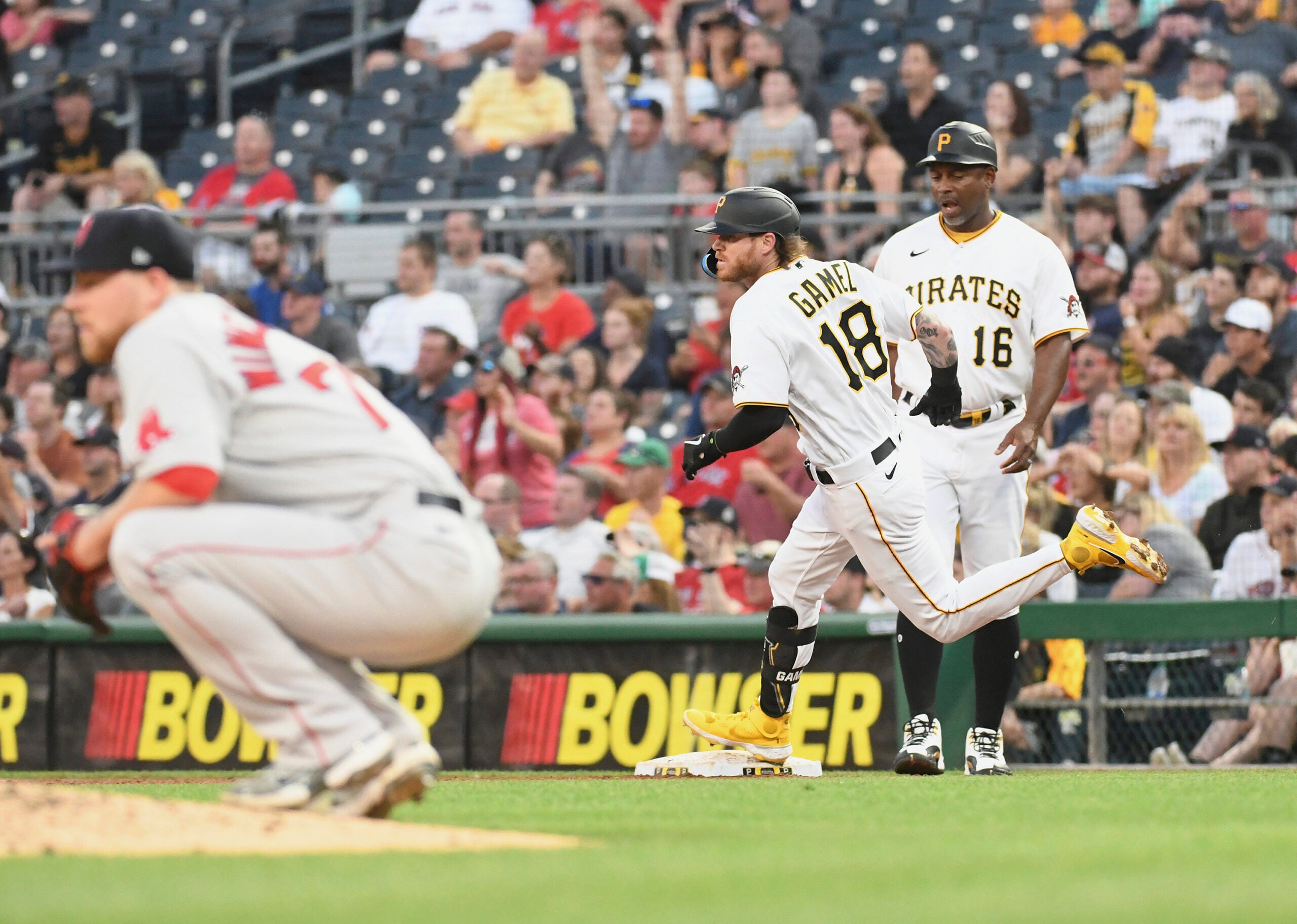 Josh Winckowski crouches as Pittsburgh's Ben Gamel rounds first base in the background.