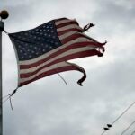 A tattered American flag blows in the wind.