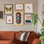 Gallery of trendy posters in elegant grey living room interior with brown corner sofa