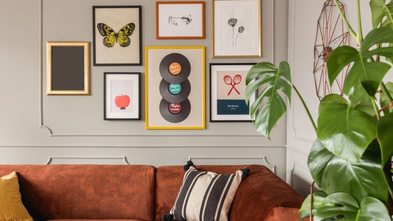 Gallery of trendy posters in elegant grey living room interior with brown corner sofa