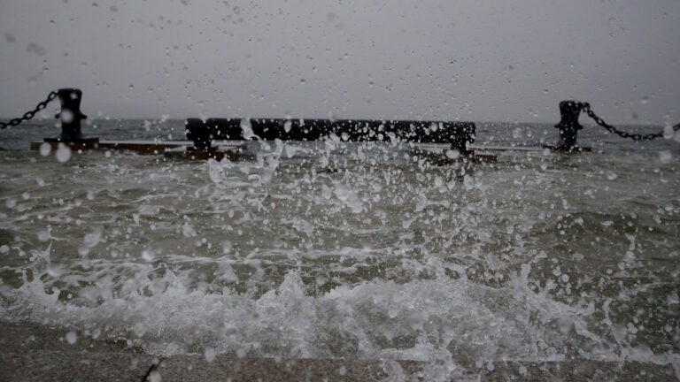 Water splashes over steps at Long Wharf high tide during a snowstorm in downtown Boston, on Jan. 29, 2022.