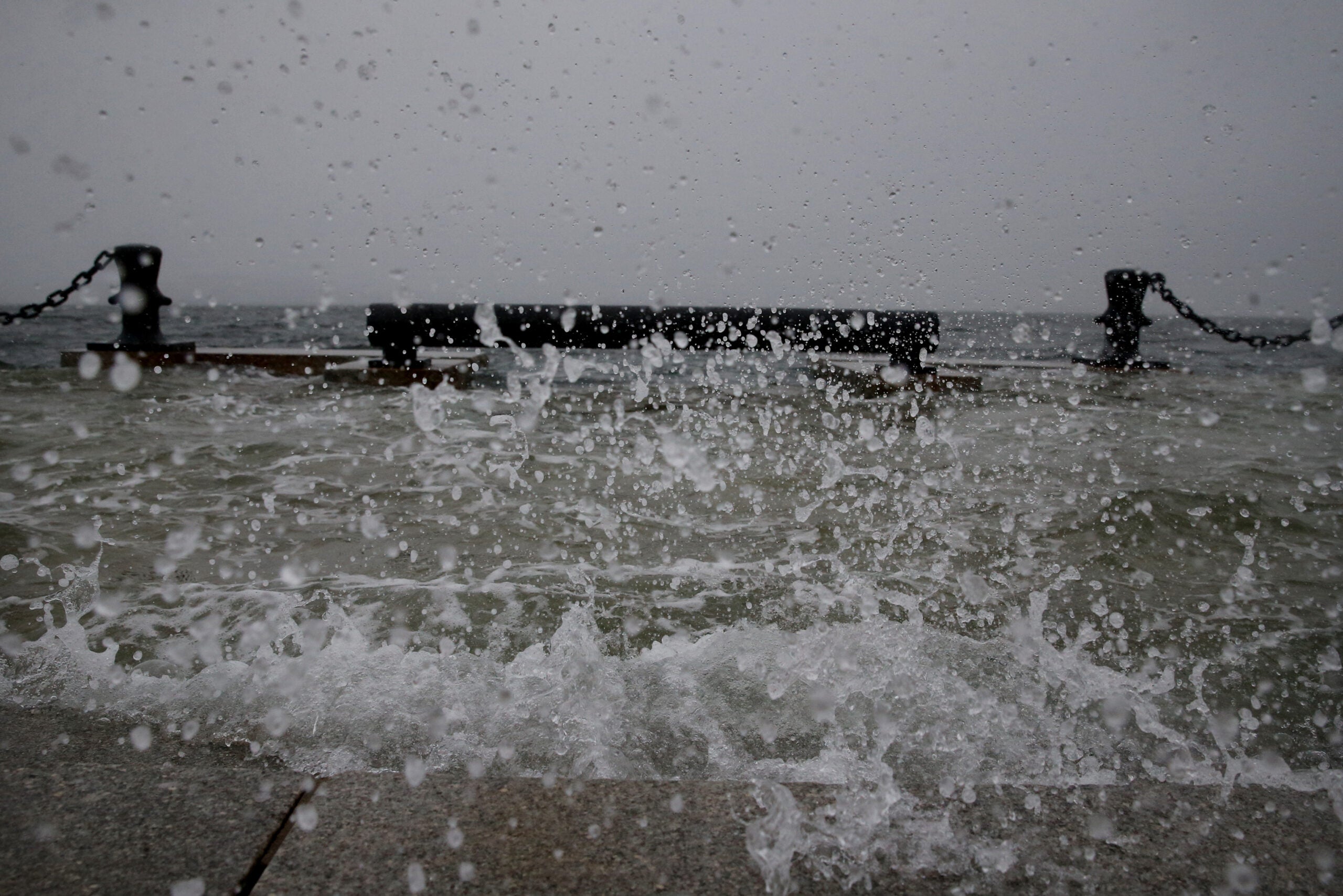 Water splashes over steps at Long Wharf high tide during a snowstorm in downtown Boston, on Jan. 29, 2022.