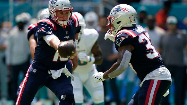 New England Patriots quarterback Mac Jones (10) hands the ball to running back Damien Harris (37) against the Miami Dolphins