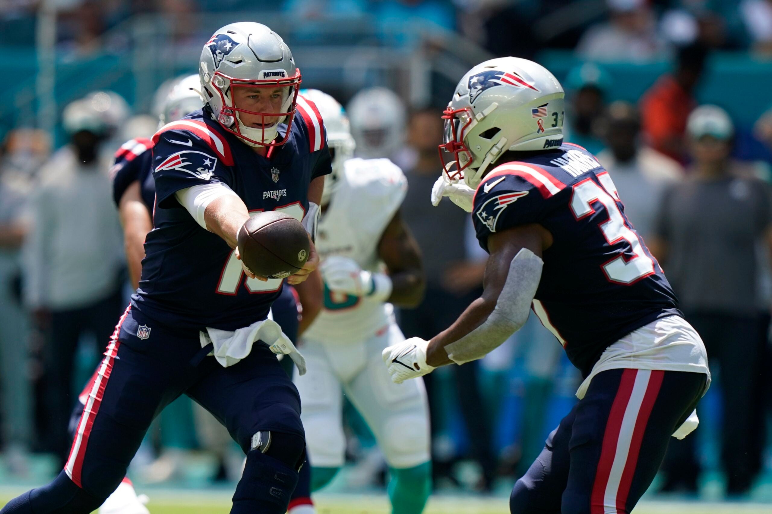 New England Patriots quarterback Mac Jones (10) hands the ball to running back Damien Harris (37) against the Miami Dolphins