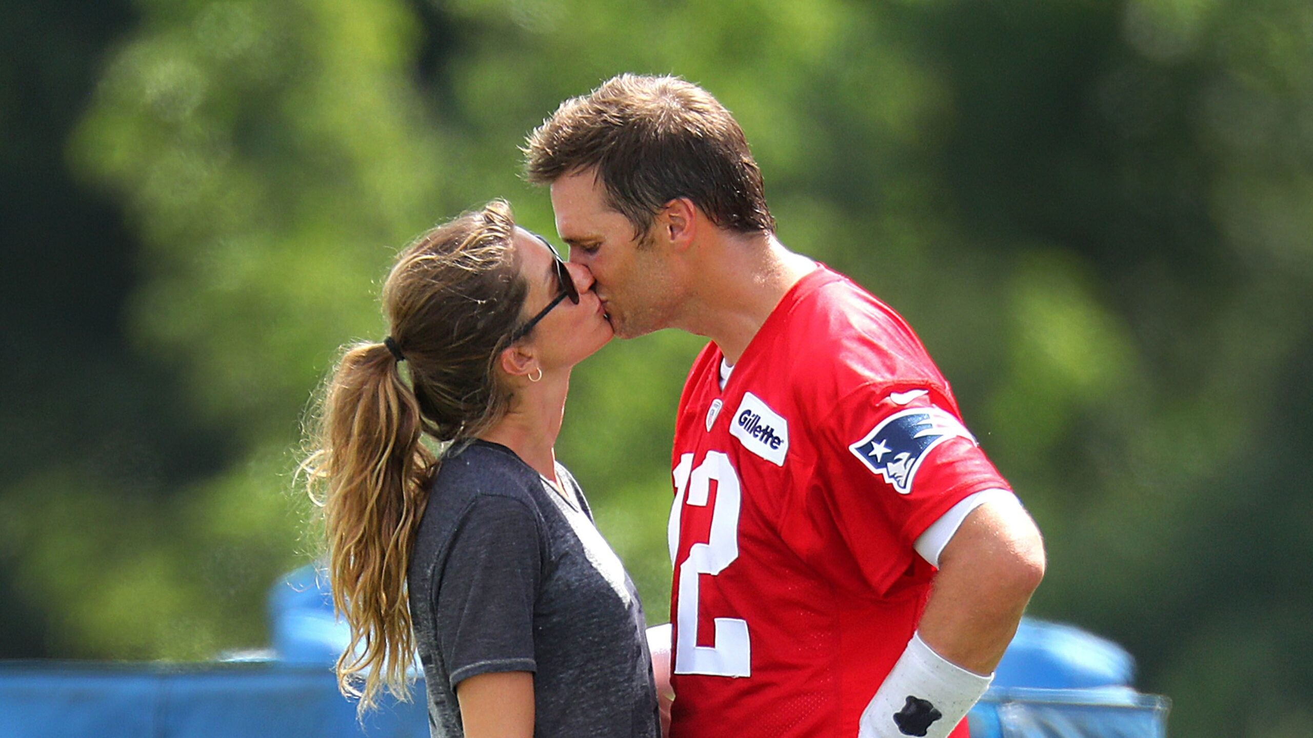 Gisele Bündchen and Tom Brady share a kiss during training camp with the Patriots in 2018.