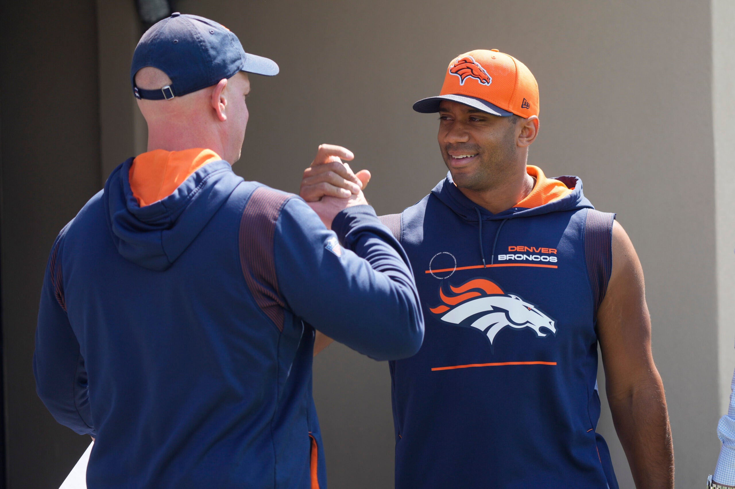 Denver Broncos head coach Nathaniel Hackett, left, greets quarterback Russell Wilson as he heads to a news conference before the NFL football team's practice Thursday, Sept. 8, 2022, at the Broncos' headquarters in Centennial, Colo. The Broncos open the NFL season Monday night against the Seahawks in Seattle.