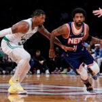 Kyrie Irving drives past Boston Celtics guard Marcus Smart.