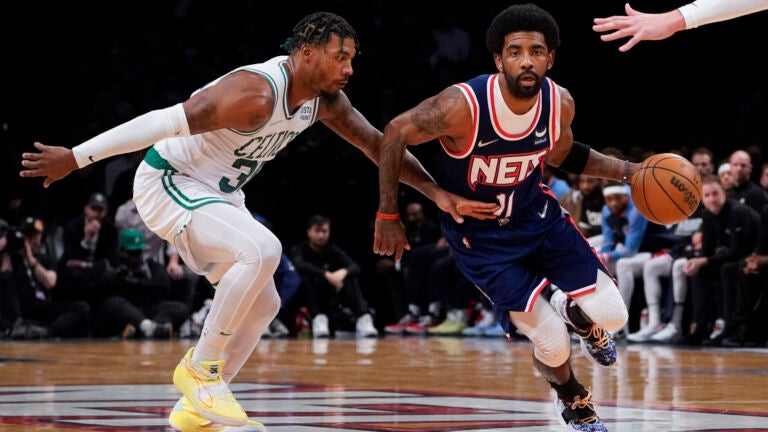 Kyrie Irving drives past Boston Celtics guard Marcus Smart.