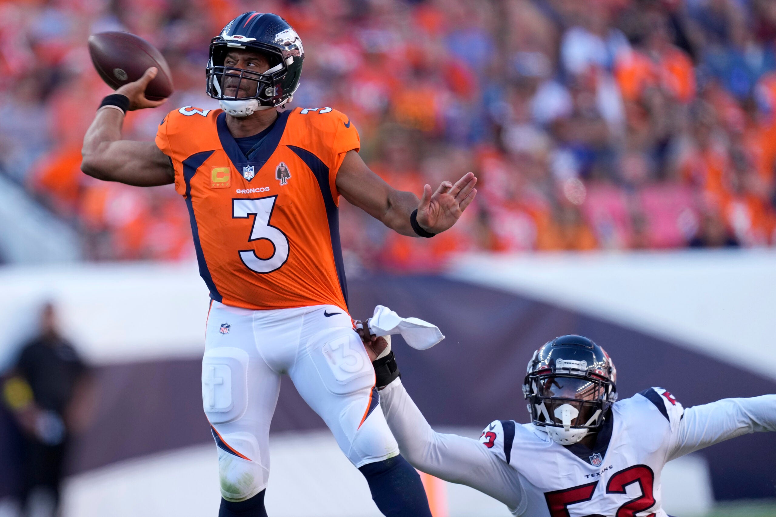 Denver Broncos quarterback Russell Wilson (3) is pressured by Houston Texans defensive end Jonathan Greenard (52) during the second half of an NFL football game, Sunday, Sept. 18, 2022, in Denver.