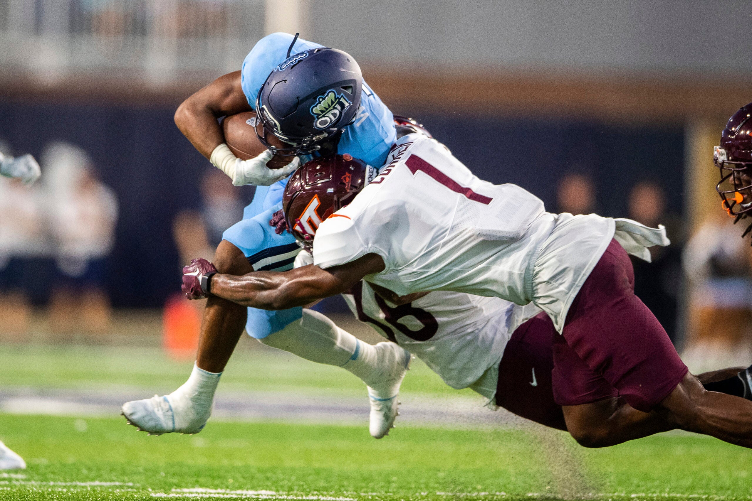 Old Dominion running back Keshawn Wicks, top, is brought down by Virginia Tech linebacker Jayden McDonald (38) and defensive back Chamarri Conner (1) during an NCAA college football game on Friday, Sept. 2, 2022, in Norfolk, Va.