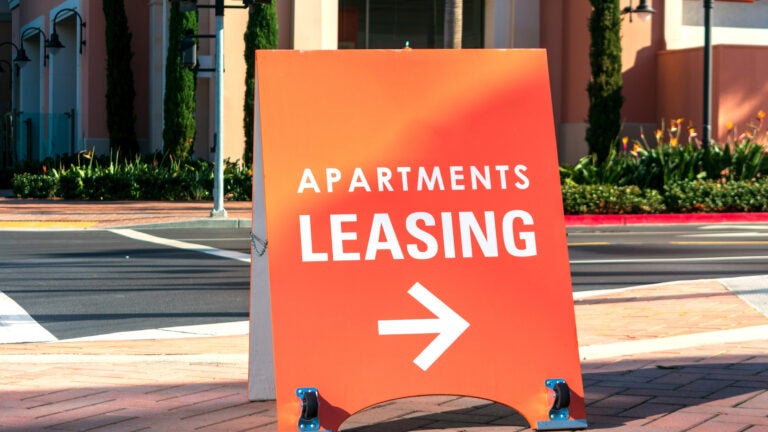 An apartment rental sign promotes the rental property and indicates the direction in which the rental office is located.