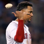 Profile of disspirited Xander Bogaerts throwing a rosin bag over his right shoulder.