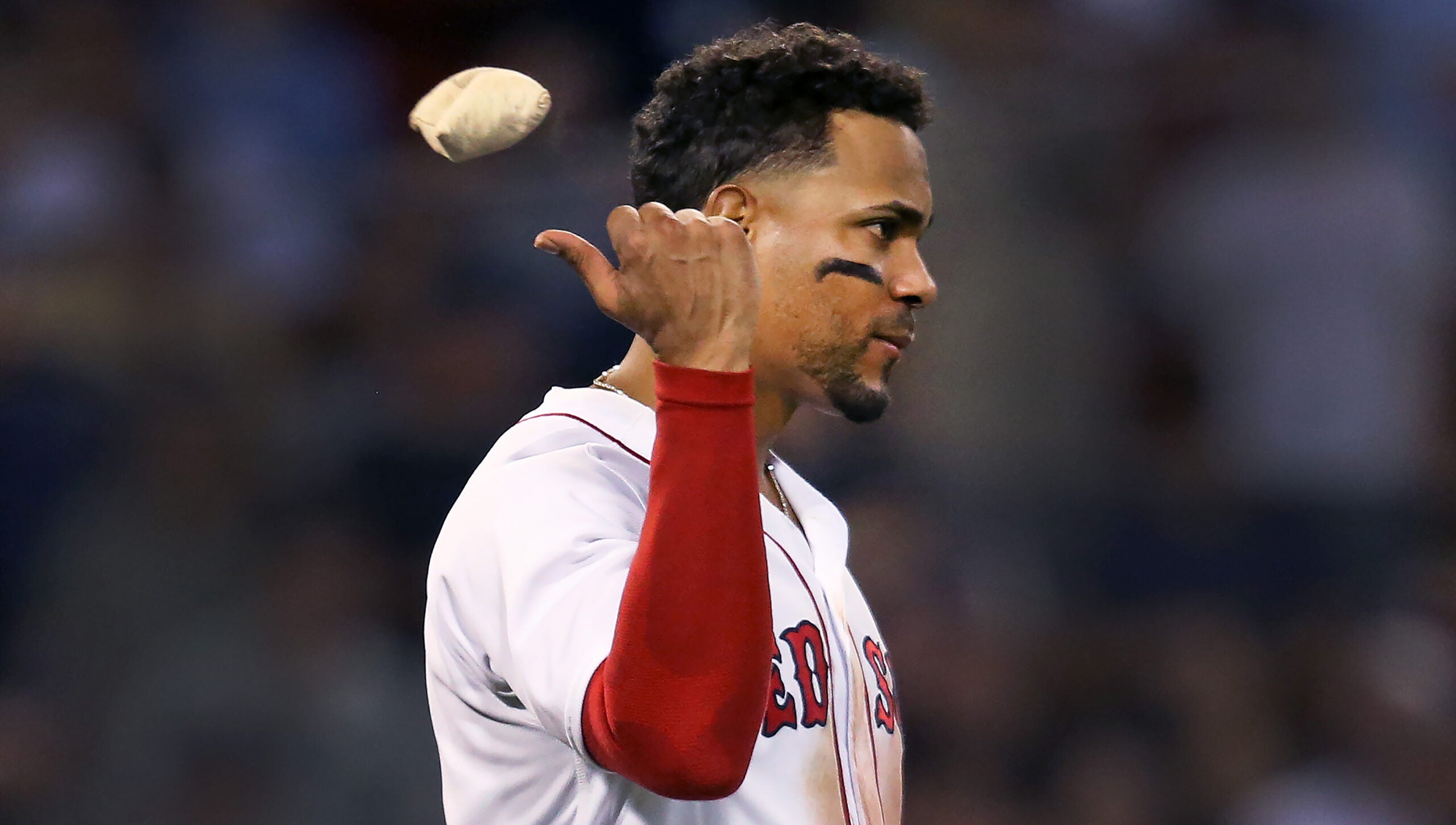 Profile of disspirited Xander Bogaerts throwing a rosin bag over his right shoulder.