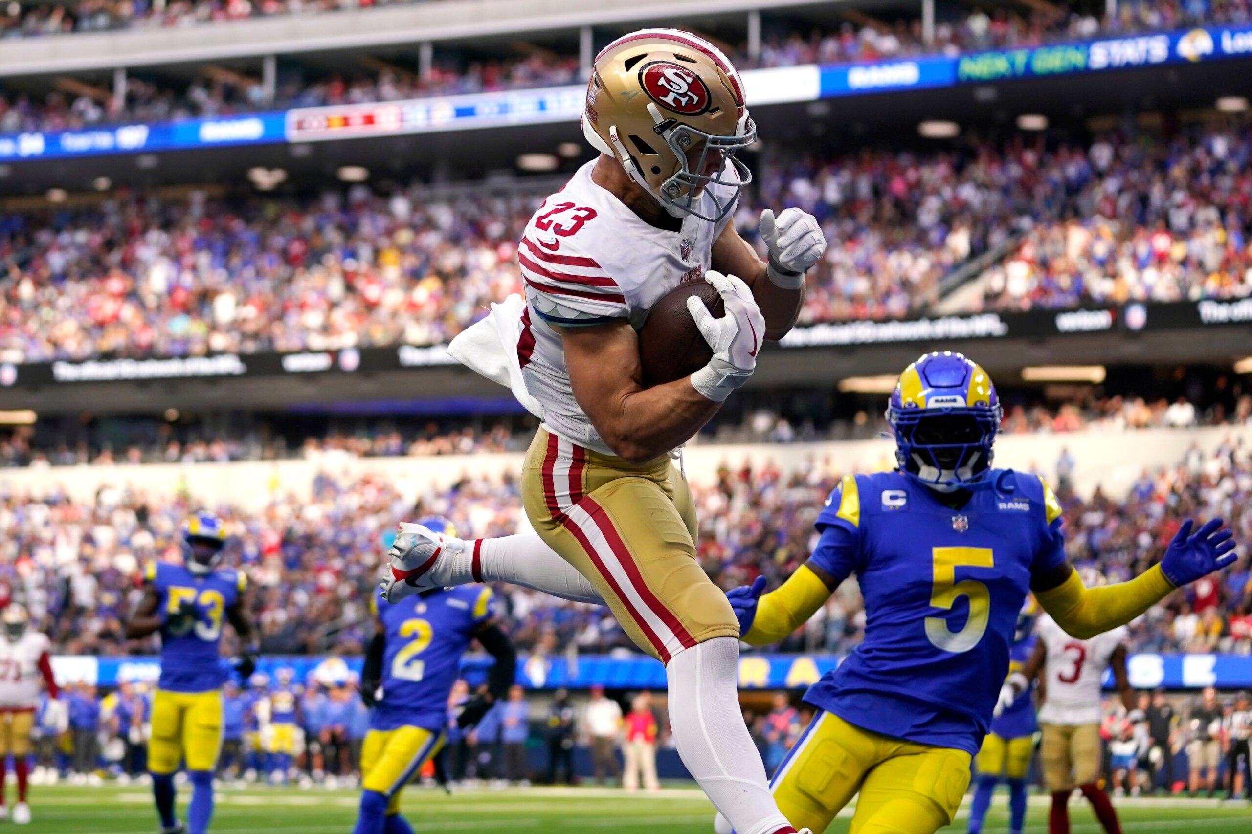 San Francisco 49ers running back Christian McCaffrey, center, comes down after making a touchdown catch as Los Angeles Rams cornerback Jalen Ramsey, right, watches during the second half of an NFL football game Sunday, Oct. 30, 2022, in Inglewood, Calif.