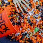 Halloween candy spilling out of orange trick or treat bucket