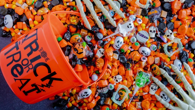 Halloween candy spilling out of orange trick or treat bucket