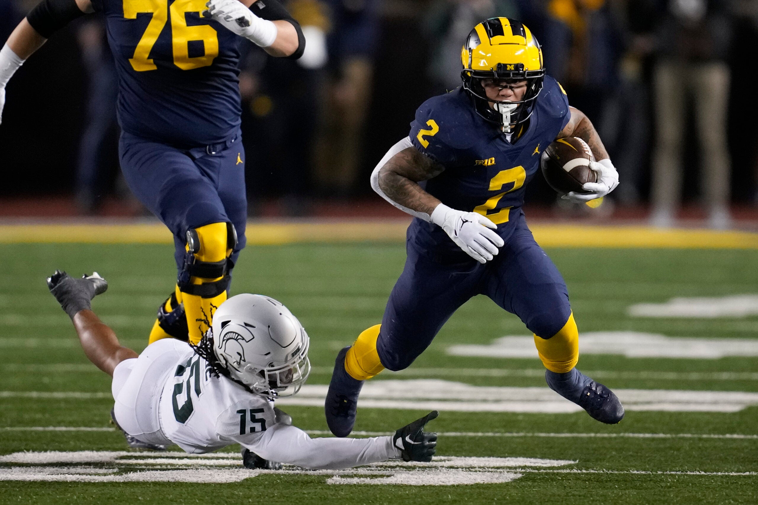 Michigan running back Blake Corum (2) escapes Michigan State safety Angelo Grose (15) in the first half of an NCAA college football game in Ann Arbor, Mich., Saturday, Oct. 29, 2022.