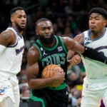 Boston Celtics guard Jaylen Brown, center, vies for control of the ball with Washington Wizards guard Monte Morris, left, and forward Rui Hachimura in the first half of an NBA basketball game, Sunday, Oct. 30, 2022, in Boston.