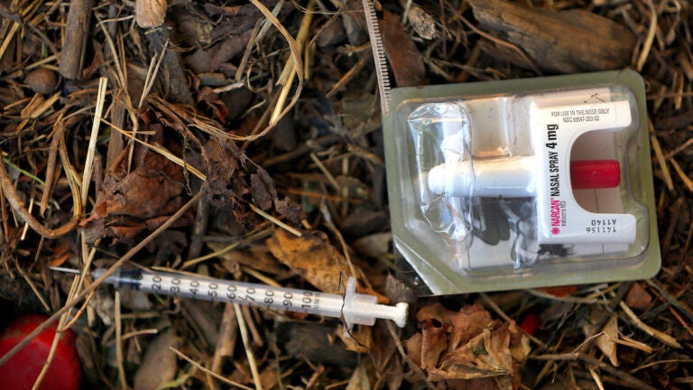 A used needle lies next to a Narcan nasal spray on the field at Clifford Park in Roxbury