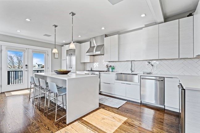 27 Mercer Street kitchen with white cabinets and waterfall island. 