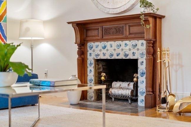 32 Avon Hill Street Fireplace in living room with traditional wood mantel and tiles surrounding the space. 