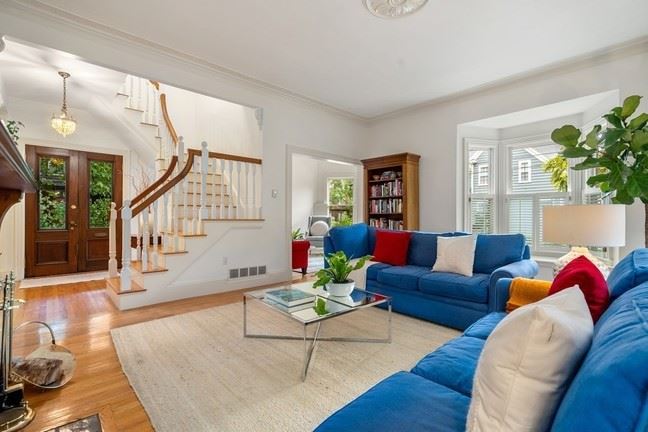 Living room at 32 Avon Hill Street with sofa and open stairs, lots of light permeating the space. 