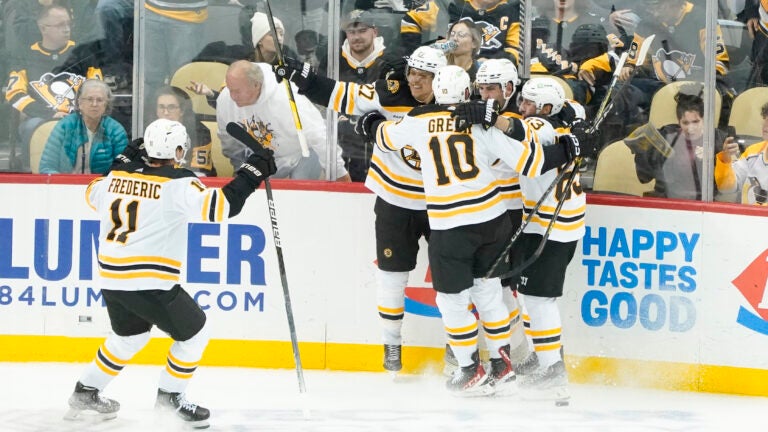 Bruins players celebrate after scoring the game winning goal against the Pittsburgh Penguins in overtime.