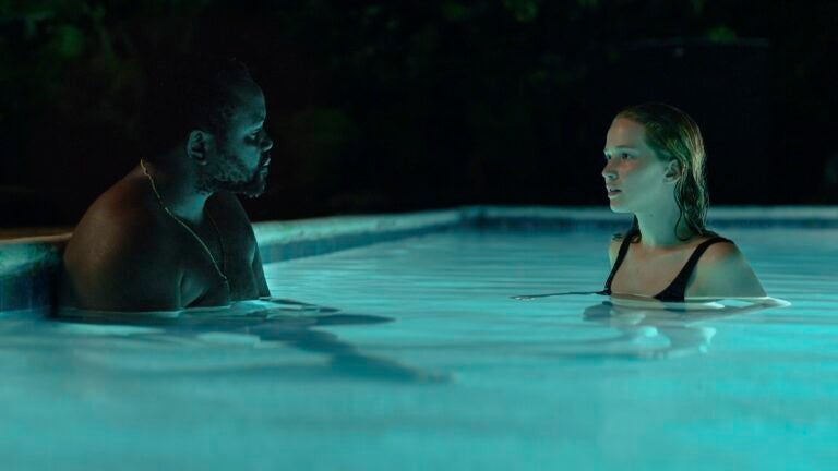 Actors Brian Tyree Henry (left) and Jennifer Lawrence (right) in a pool at night in the movie "Causeway."