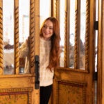 Lindsay Lohan enters a room wearing a white sweater in the Netflix holiday movie "Falling For Christmas."