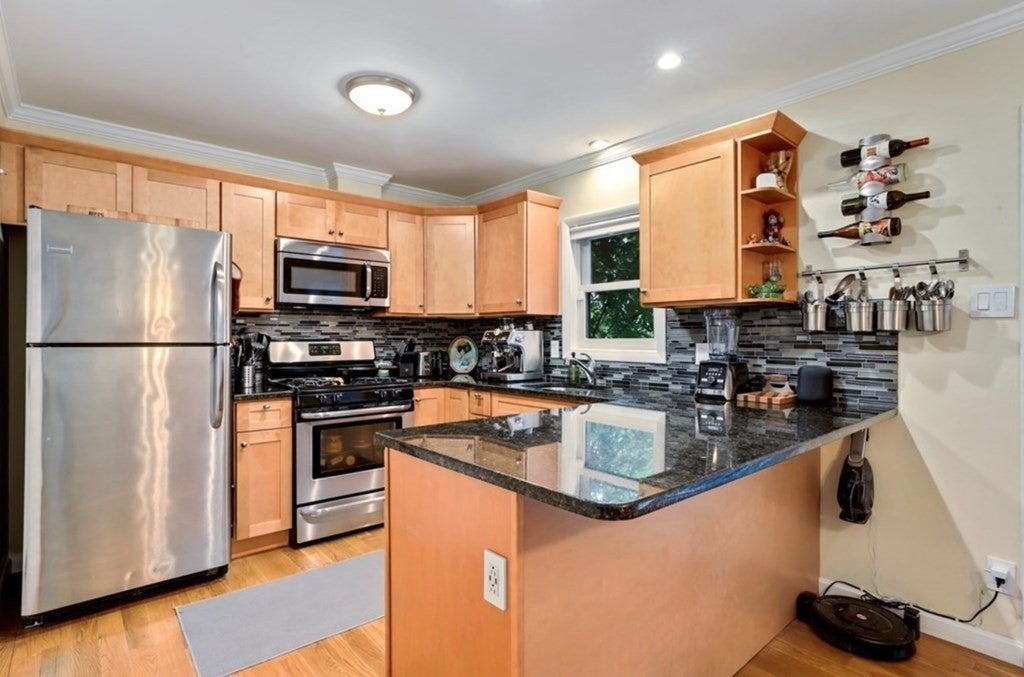 2 Howe Ter, Unit 6 kitchen with bar top seating and wood cabinets.