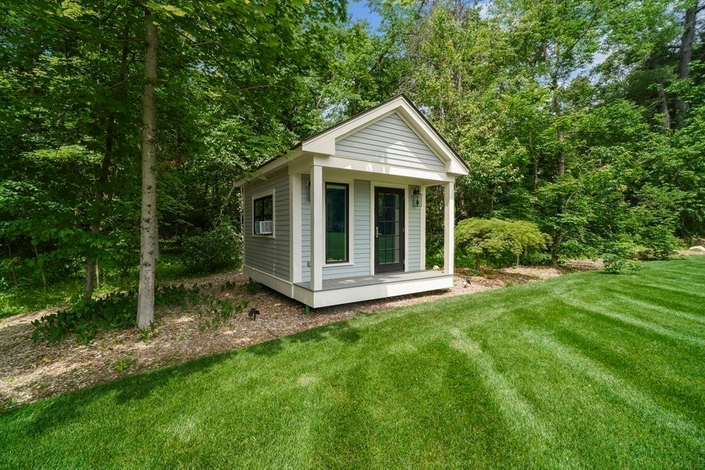 52 Heather Lane has a playhouse in the backyard that is in the traditional design of the updated house.