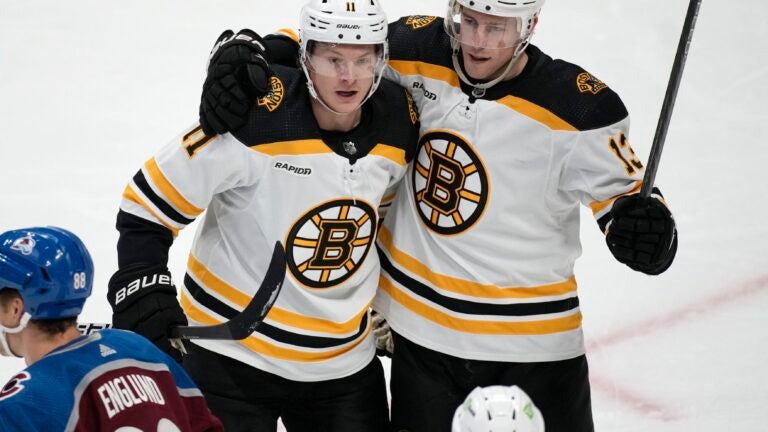 Bruins center Trent Frederic, back left, is congratulated on his goal against the Colorado Avalanche, by center Charlie Coyle during the third period