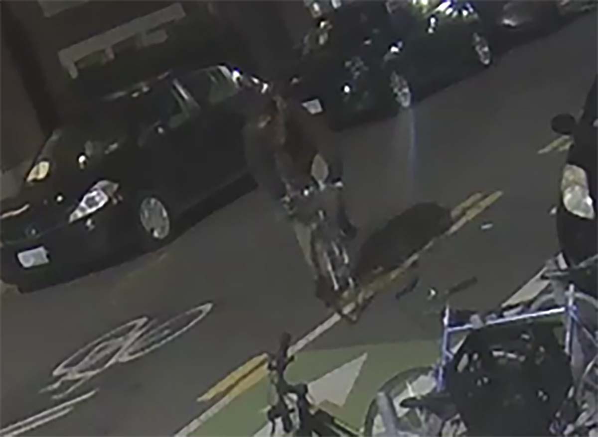 alt = a bicyclist – described as a white man, approximately 50-years-old, wearing a navy fleece and no helmet – was captured riding on a street in Cambridge