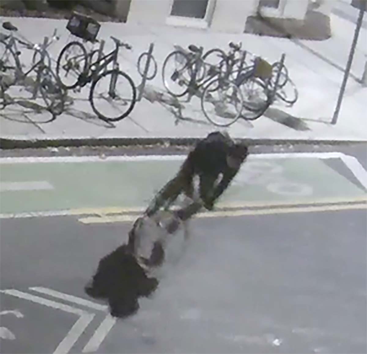 alt = a bicyclist – described as a white man, approximately 50-years-old, wearing a navy fleece and no helmet – was captured riding on a street in Cambridge