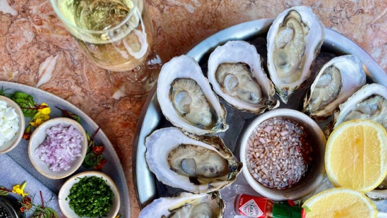 Trays of oysters and mignonette with a glass of champagne at Oak Long Bar