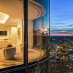 One Dalton image from outside the living room with lights on in the home and city view just beyond the penthouse.